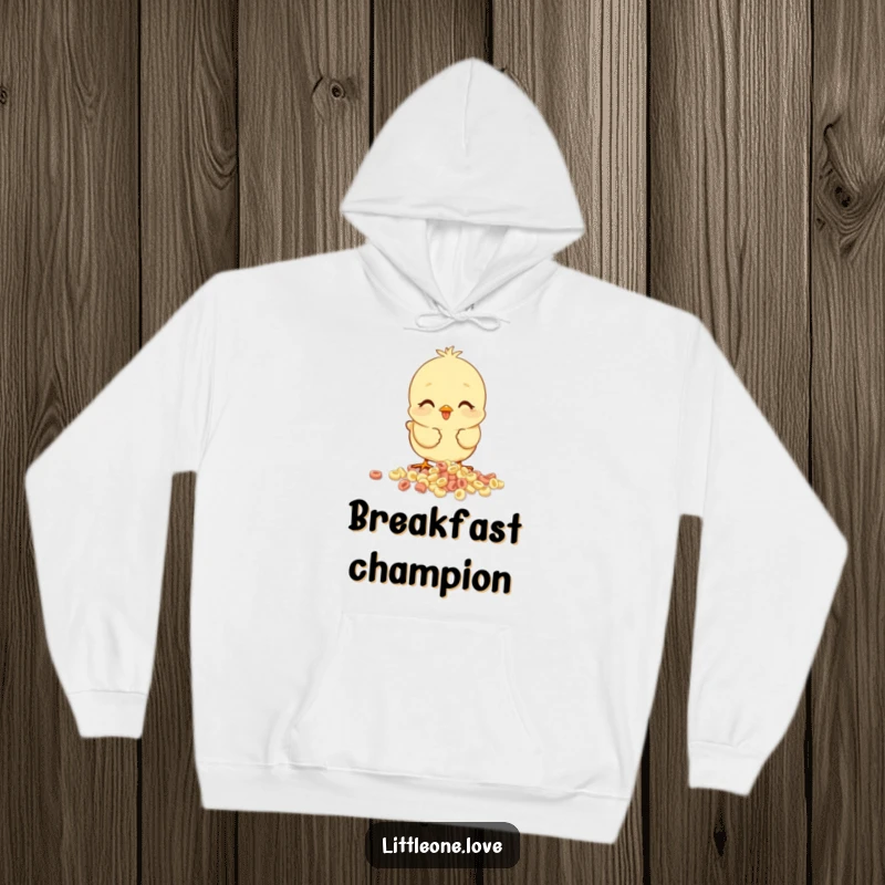 Funny baby chick hoodie, happy chick pecking at spilled cereal, cozy and humorous design for comfortable wear.
